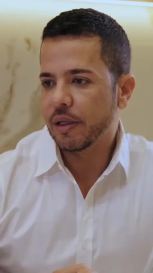 Alexandre Chaves de camisa branca conversando durante a consulta